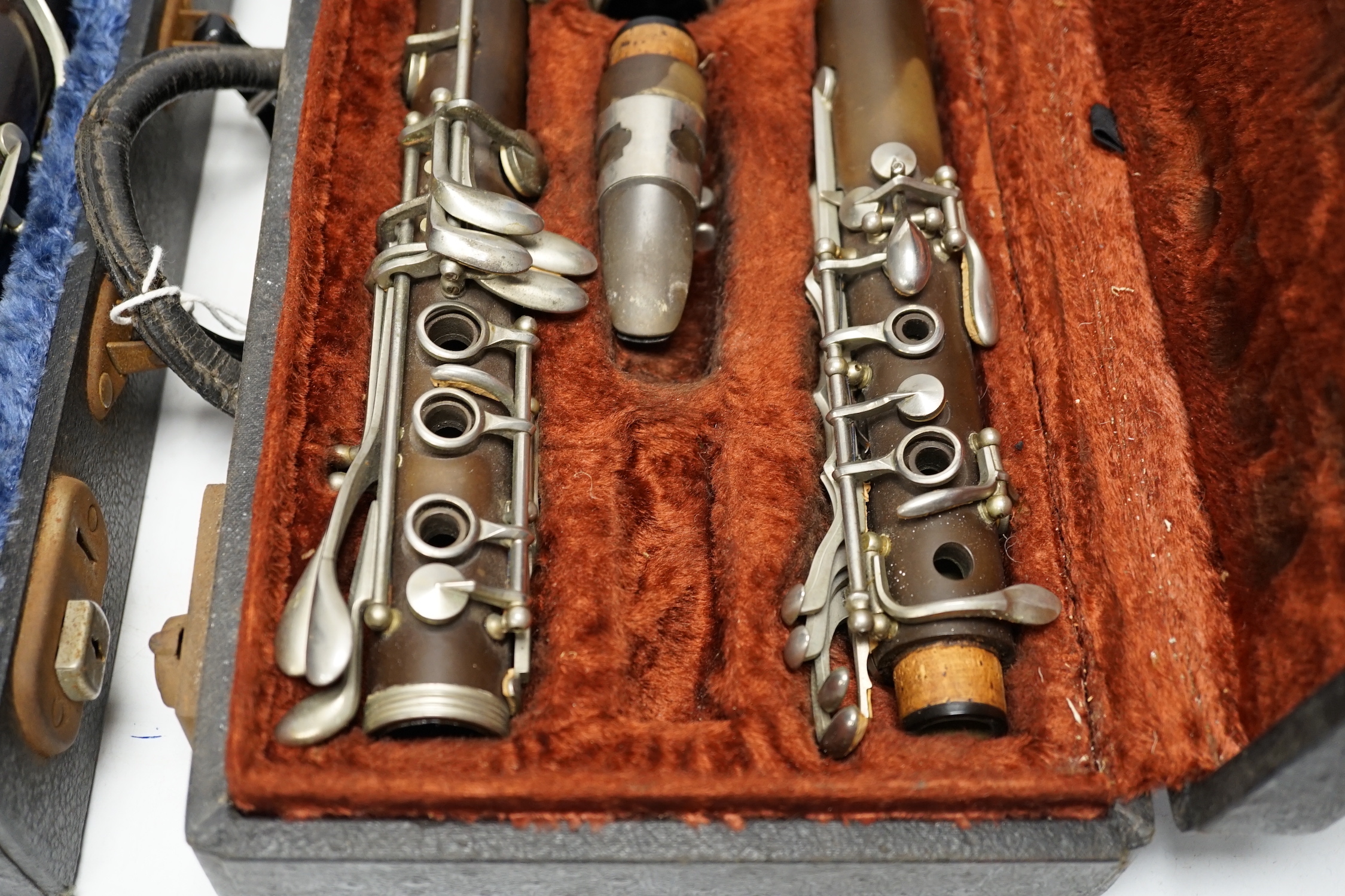 Two cased unmarked clarinets with early key systems, one mid 19th century in rosewood, one with light brown Bakelite body